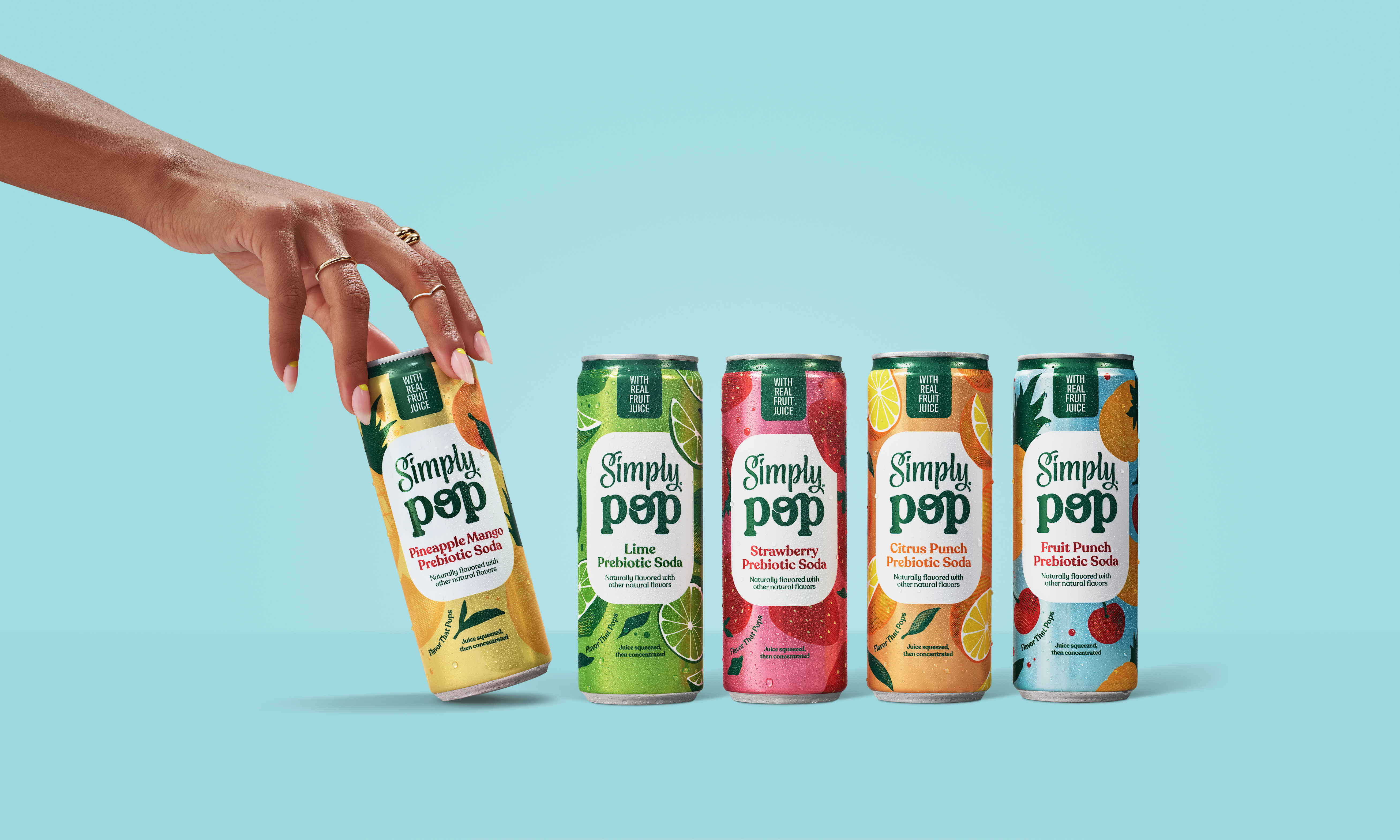 Different flavors of Simply Pop cans lined up with a hand grabbing the first can